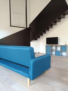 マントヴァにあるLe Residenze di Mantovaの階段のあるリビングルーム(青いソファ付)