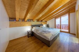 - une chambre avec un lit et un plafond en bois dans l'établissement Apartment Pipistrelle by Dieckereise, à Verbier