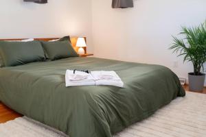 ein grünes Bett mit zwei Handtüchern darüber in der Unterkunft The Mulberry on Bragg in Raleigh