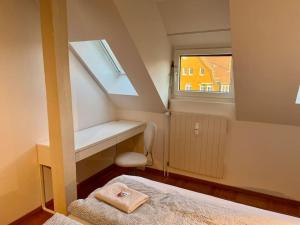 a small room with a bed and a window at Quiet Attic-Apartment Bern Center in Bern
