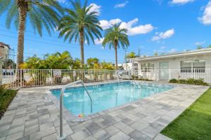 a swimming pool with palm trees in front of a building at Hotel Cabana Clearwater Beach in Clearwater Beach