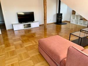 a living room with a couch and a flat screen tv at Quiet Attic-Apartment Bern Center in Bern