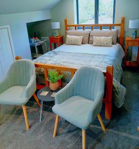 een slaapkamer met een bed en 2 stoelen bij Englefield Guesthouse in Goathland