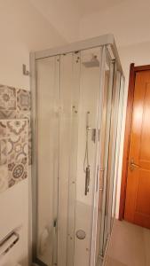 una doccia con porta in vetro in bagno di Casa Anselmo Guest House a Pagani
