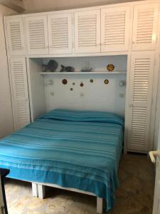 una camera da letto con letto con armadi bianchi e lenzuola blu di Sea View Apartment in the Greek Nature a Gouviá