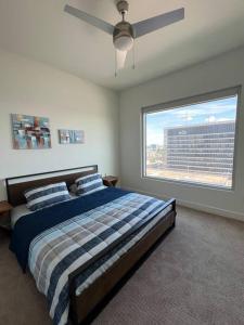 a bedroom with a bed and a large window at Midtown High Rise Escape in Houston