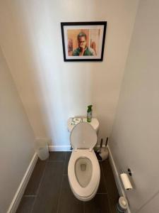 a bathroom with a toilet with a picture on the wall at Midtown High Rise Escape in Houston