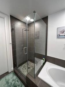 a bathroom with a shower and a tub and a sink at Midtown High Rise Escape in Houston