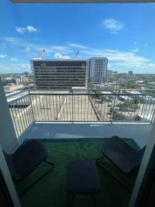 a balcony with two chairs and a view of a city at Midtown High Rise Escape in Houston
