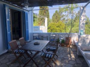 patio con tavolo e sedie sotto il portico di Sea View Apartment in the Greek Nature a Gouviá