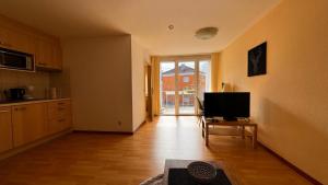 an empty living room with a television and a kitchen at 2 Zimmer Wohnung am Milaneo Stadtmitte HBF Stuttgart in Stuttgart