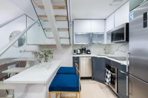 a kitchen with a white table and blue chairs at 75-4B Duplex 3BR Brand new W D Prime UES in New York