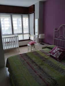 een slaapkamer met een bed en paarse muren en ramen bij Apartamento Noja Beach in Noja