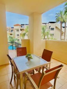 a table and chairs in a room with a balcony at Roda Golf. Poolside apartment in Murcia