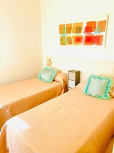 a room with two beds and a painting on the wall at Roda Golf. Poolside apartment in Murcia +19 photos
