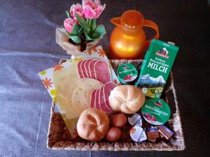 a basket of food with a vase of pink flowers at Klettnerlehen in Ramsau