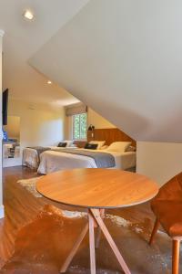 カンポス・ド・ジョルドンにあるTi Voglio Beneのベッド2台と木製テーブルが備わる客室です。