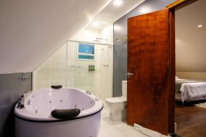 a bathroom with a bath tub and a toilet at Ti Voglio Bene in Campos do Jordão