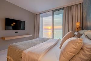 a bedroom with a large bed and a large window at Blu Mare Hotel in Novigrad Istria