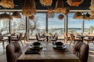 een eetkamer met tafels en stoelen en een groot raam bij Blu Mare Hotel in Novigrad Istria