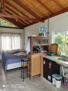 a kitchen with a bed and a sink in a room at Chalés do GreenGo in Santo Antônio do Pinhal