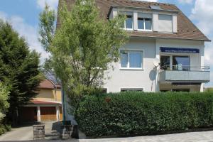 a white house with a tree in front of it at FeWo Bayha "Im Ort" in Langenargen