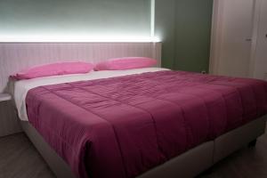 una camera da letto con un grande letto con una coperta rosa di Tenuta Pietravera a Furnari