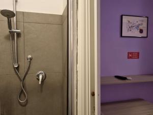 um chuveiro numa casa de banho com uma parede roxa em Sweet Dream em Passignano sul Trasimeno