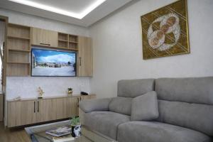 a living room with a couch and a flat screen tv at Welcome house appart'hôtel in Tangier
