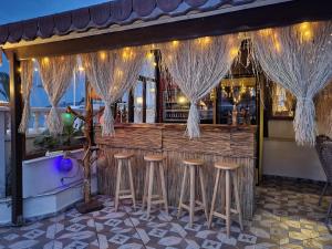 a bar with stools in front of a bar at Sözer Otel in Ayvalık
