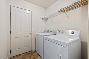 Un lavadero blanco con lavadora y secadora. en Charming Private Twnhome w/ Large Fenced Yard (58), en Meridian
