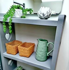 a shelf with baskets and a green vase on it at Englefield Guesthouse in Goathland