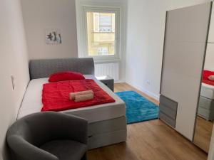 a bedroom with a bed and a chair and a mirror at Schöner Wohnen in Stuttgart Ost in Stuttgart