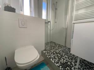 a white bathroom with a toilet and a shower at Schöner Wohnen in Stuttgart Ost in Stuttgart +8 photos