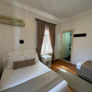 - une chambre avec un lit blanc et une fenêtre dans l'établissement Sözer Otel, à Ayvalık