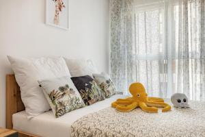a stuffed octopus sitting on top of a bed at Apartament Fauna- blisko morza in Gdańsk