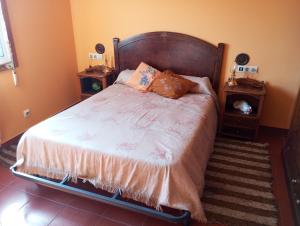 Gil的住宿－Habitación en A Armenteira，一间卧室配有一张带2个床头柜和2张桌子的床