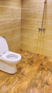 baño con aseo y suelo de madera en إستراحة المزرعة en Abha