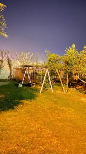 a swing set in a field of grass at إستراحة المزرعة in Abha