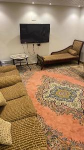 sala de estar con sofá y TV de pantalla plana en إستراحة المزرعة, en Abha