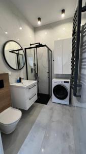 a bathroom with a toilet and a washing machine at CityCenterApartments/M32/6 in Bielsko-Biała