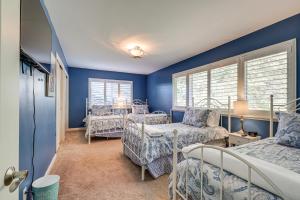 1 dormitorio con paredes azules, 2 camas y mesa en Lakefront California Escape with Deck and Boat Dock!, en Clearlake