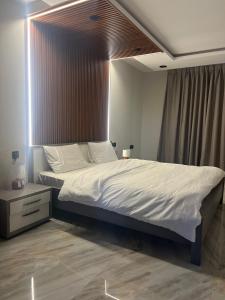 a bedroom with a large bed with white sheets at شاليهات السلطان 3 غرف قريبه من الحرم بحي الملك فهد in Sīdī Ḩamzah