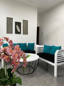 ein Wohnzimmer mit einem Sofa, einem Tisch und Blumen in der Unterkunft Cinnamon apartment in Panadura