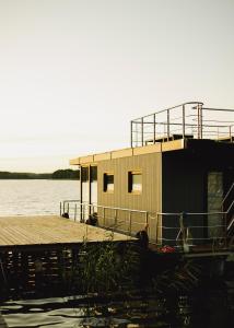 a small building on a dock on a body of water at RiW Małe Swory - Domek pływający Houseboat i domki drewniane in Małe Swornegacie