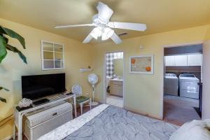 a living room with a ceiling fan and a kitchen at Boat Slip Access North Padre Island Condo! in Padre Island