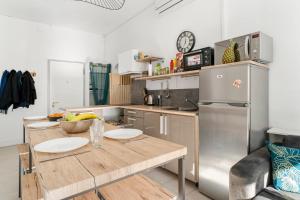 eine Küche mit einem Holztisch und einem Kühlschrank in der Unterkunft Appartement Fabron - Welkeys in Nizza