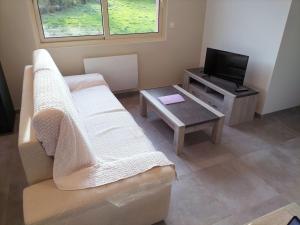 a living room with a couch and a table and a tv at Gîte Notre-Dame in Saint-Riquier