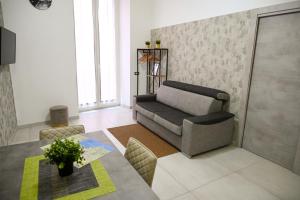 ein Wohnzimmer mit einem Sofa und einem Tisch in der Unterkunft Victry's Houses Chiaia in Neapel