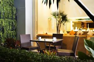 ein Tisch und Stühle auf einer Terrasse mit einer Couch in der Unterkunft Citypoint Hotel in Bangkok